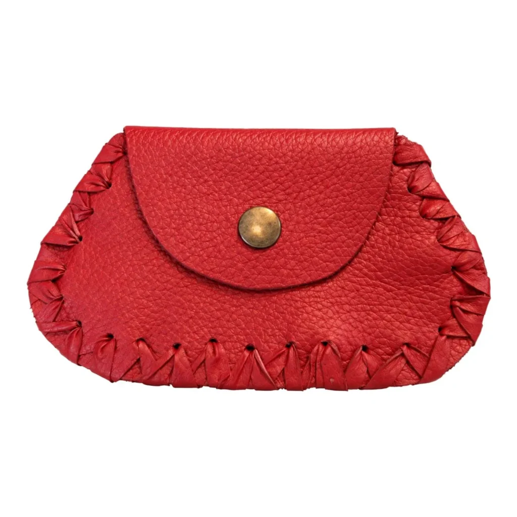 Monedero rojo de cuero terminado, con broche metálico y borde tejido con tiras de cuero, sobre fondo blanco.